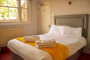 a bedroom with a bed with two towels on it at Rose and Crown B&B in Burwash