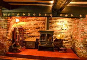 a brick room with a stove in a brick wall at Rose and Crown B&B in Burwash