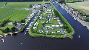 WarmondGlamping de Hof van Eeden的空中俯瞰水中岛屿上的一组房屋