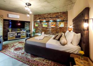 a bedroom with a large bed and a brick wall at Къща за гости Casa La Tinozza in Hisarya