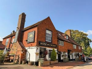 an old brick building with a clock on it at Rose and Crown B&B in Burwash