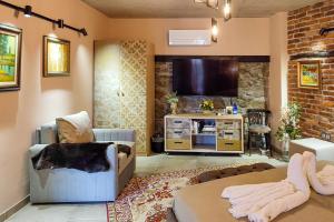 a living room with a couch and a tv at Къща за гости Casa La Tinozza in Hisarya