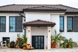 a house with a black door and a tile roof at Къща за гости Casa La Tinozza in Hisarya +35 photos