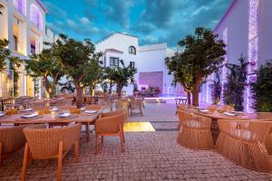 an outdoor patio with tables and chairs and trees at P SANTA CLARA HOTEL BOUTIQUE By Sojo in Córdoba
