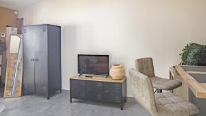 a living room with a tv and two chairs at Le Loft Savinien - Proche Troyes - 3 pers in Sainte-Savine