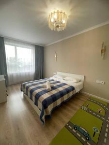 a bedroom with a bed with a checkered blanket at 3 bedroom apartment with 2 restroom in the Ala Park Business class in Almaty