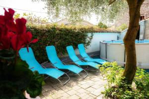 a group of blue chairs sitting on a patio at Tolles Ferienhaus in Peresiji mit Privatem Pool in Peresiji