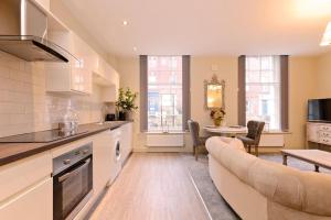 a kitchen and living room with a couch and a table at The Bessemer Suite in Sheffield