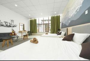 ein großes Schlafzimmer mit einem großen weißen Bett und grünen Vorhängen in der Unterkunft Alleyway home in Ho-Chi-Minh-Stadt