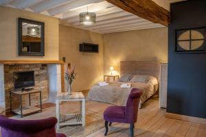 a bedroom with a bed and a fireplace at Le P'tit Louis in Saint-Cyr-les-Colons +78 photos