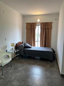 a bedroom with a bed and a table and a window at Complejo Aloe Vera C in Villa Dolores