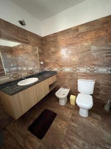 a bathroom with a toilet and a sink at Complejo Aloe Vera C in Villa Dolores