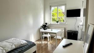 a small living room with a table and a bed at Work & Stay- vollausgestattet mit Garten & Parkplatz in Blankenfelde