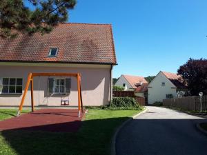 a swing set in the yard of a house at Ferienhaus Bad Waltersdorf im Biodorf in Bad Waltersdorf