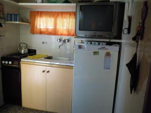 a small kitchen with a tv on top of a refrigerator at Casa Bichi in Villa Gesell