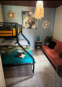 a bedroom with a bunk bed and a couch at Kaz à Naja in Saint-Louis