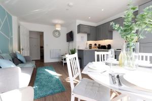 a kitchen and living room with a white table and chairs at Cardiff City Centre apartment Private Parking in Cardiff +44 photos