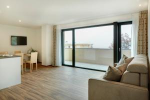 a living room with a couch and a table and a kitchen at Residence Ladurn in Tirolo
