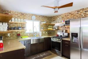 a kitchen with stainless steel appliances and a brick wall at Relaxation Retreat Home with Hot Tub Gym & Sauna in Prattsville