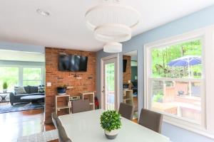 a dining room with a table and a tv on a brick wall at Relaxation Retreat Home with Hot Tub Gym & Sauna in Prattsville