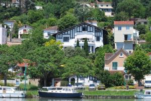 a group of houses on a hill with boats in the water at Quand la ville dort in Agen