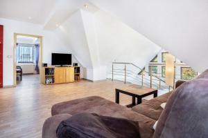 a living room with a couch and a tv at Ferienwohnung über 2 Etagen in Trollenhagen