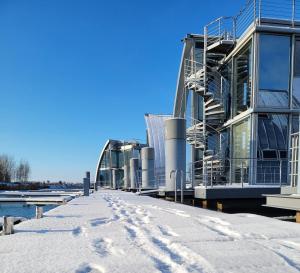 a building with snow on the ground in front of it at schwimmende Ferienwohnung Rooftop in Elsterheide