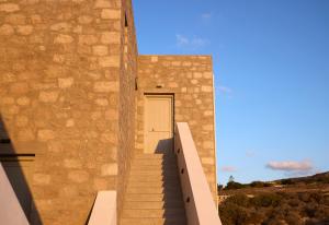a staircase leading to a door in a stone building at Kedros Milos Suites in Adamas