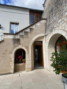 an entrance to a building with arches and flowers at Manoir des Roches 41 in Bourré