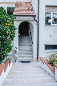 an entrance to a house with stairs and an orange tree at Apolloni di Loano appartamento privato - Codici Citra visibili su STRUTTURA in Loano