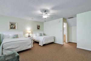 a bedroom with two beds and a ceiling fan at Pelicans Reef by the beach in Myrtle Beach