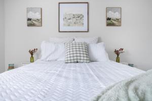a white bed with a pillow on top of it at Waiting to Excell in Clarksville