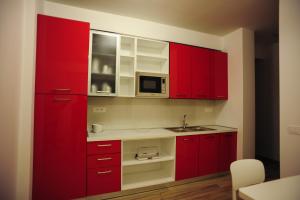a red kitchen with a sink and a microwave at B&B del Parco in Cosenza