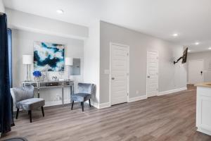a living room with white walls and a desk and chairs at Waiting to Excell in Clarksville