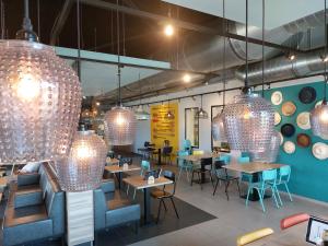 a restaurant with tables and chairs and chandeliers at Kompas Camping Nieuwpoort in Nieuwpoort