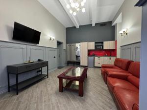 a living room with a red couch and a flat screen tv at Aqvium in Dnipro