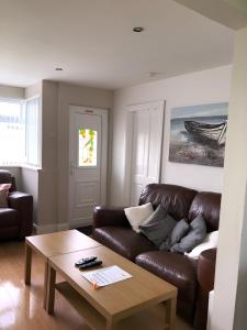 a living room with a brown leather couch and a table at Chalet 147 South Shore Bridlington in Bessingby