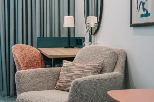 a living room with a chair and a table at voco Winchester Hotel & Spa by IHG in Winchester +140 photos