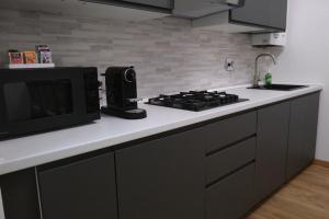 a kitchen with a microwave and a stove top oven at Porto Antico Apartment in Genoa