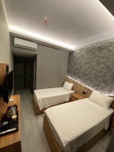 シャンルウルファにあるOtel OrtaDoğuのベッド2台とテレビがあるホテルの部屋