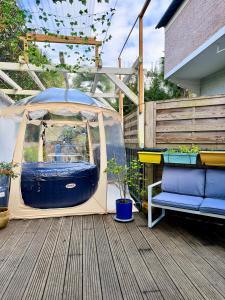 a tent on a deck with a bench and plants at Duplex Trespoey - SPA - Place de parking in Pau