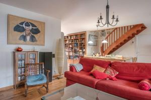 salon z czerwoną kanapą i schodami w obiekcie Pour des vacances en famille à Sarzeau w mieście Sarzeau