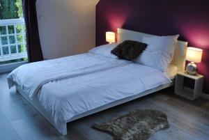 a bedroom with a large white bed with two lamps at Villa Donar in Cologne