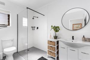 Un baño blanco con lavabo y espejo. en 8 on Nivenia by Host Agents, en Bettyʼs Bay 42 fotos más