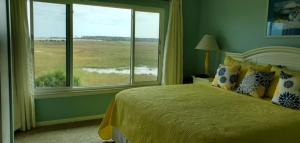 a bedroom with a bed and a large window at Sunny Spot, Best Views in St. Helena Island