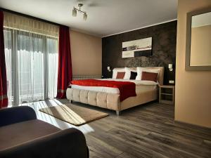 a bedroom with a large bed with a red blanket at Pensiunea Andrei Moieciu in Moieciu de Jos +57 photos