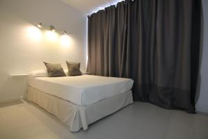 una camera con letto bianco con tenda di Costa Mar Sea View a Puerto del Carmen