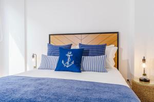 a bedroom with a bed with blue and white pillows at Varanda Azul - First Mate Loft (City Centre) in Ponta Delgada