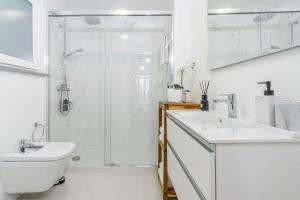 a white bathroom with a shower and a sink at Varanda Azul - First Mate Loft (City Centre) in Ponta Delgada +15 photos