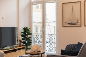 a living room with a tv and a window at Varanda Azul - First Mate Loft (City Centre) in Ponta Delgada